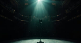 Vintage microphone stand illuminated by a single spotlight on an empty gothic stage in a darkened concert hall