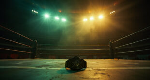 An empty wrestling ring illuminated by a single spotlight in an abandoned arena at twilight, with a championship belt on a pedestal