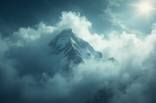 Snow-covered mountain peak engulfed by storm clouds in remote Karakoram range during harsh weather conditions