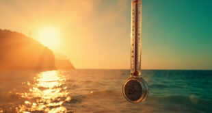 Floating thermometer displaying 29 degrees Celsius over shimmering Mediterranean Sea under scorching midday sun
