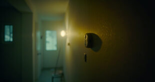 Empty vacation rental interior with carbon monoxide detector on wall, showing warning signs amid eerie stillness