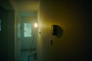 Empty vacation rental interior with carbon monoxide detector on wall, showing warning signs amid eerie stillness