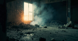 Scattered firework debris on concrete floor of abandoned residential garage after explosion, lit dramatically in charcoal gray and ash white