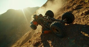 Overturned ATV abandoned on dangerous rocky cliff edge near Malibu, steel gray frame with orange rust damage