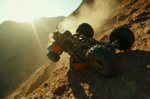 Overturned ATV abandoned on dangerous rocky cliff edge near Malibu, steel gray frame with orange rust damage