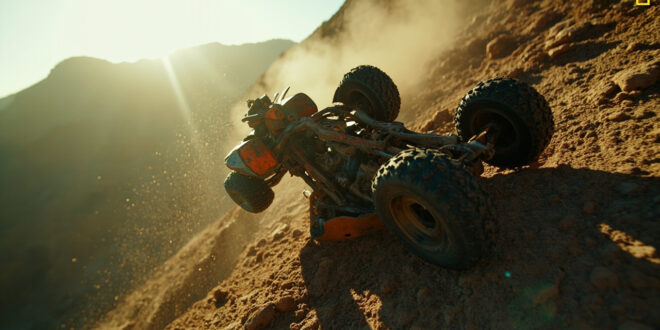 Overturned ATV abandoned on dangerous rocky cliff edge near Malibu, steel gray frame with orange rust damage