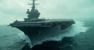Large military aircraft carrier sailing through dark ocean waters with fighter jets visible on flight deck