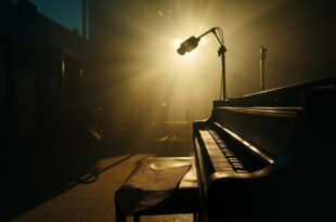 Unopened sheet music rests on a piano bench in an abandoned recording studio at twilight, with a silent microphone stand nearby.