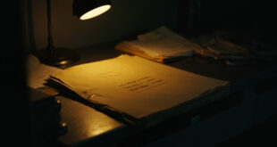 Manila evidence folder on metal desk in dark investigation room