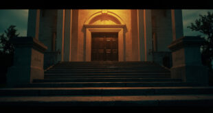 Empty stone courthouse steps at dusk, leading to closed doors adorned with justice scales in somber lighting