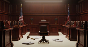 Empty courthouse witness stand with microphone and scattered legal papers on wooden desk