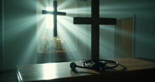 Empty medical consultation room with stethoscope beside wooden cross on desk, blending hospital and chapel elements