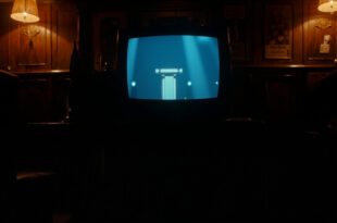 Television screen showing quiz show set mounted on pub wall with empty tables and chairs visible