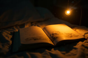 The Giving Tree book lies open on a hospital bedside table at night, bathed in warm amber light against white walls.