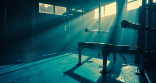 Abandoned football training equipment sits unused in a dimly lit fitness facility at dawn, highlighted by morning light