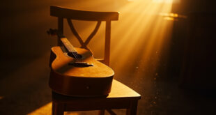 Acoustic guitar resting on vacant wooden chair in empty music room bathed in soft morning light