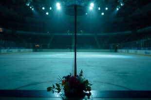 Hockey stick leaning against arena boards with memorial flowers and soft arena lighting