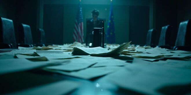 Abandoned negotiation table with scattered trade documents in empty corporate boardroom featuring EU and US flags