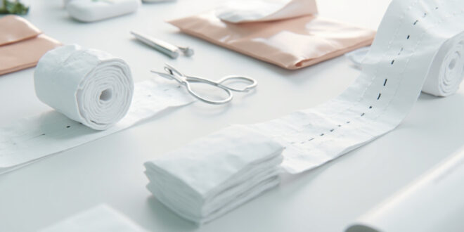 White medical bandages and surgical gauze with visible stitches in sterile clinical setting