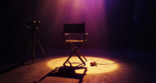 Empty spotlight illuminates abandoned film camera and wilted rose on director's chair in dimmed theater at twilight