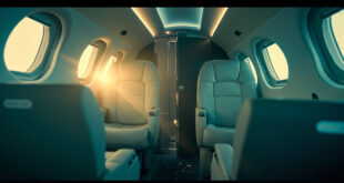 Empty luxury private jet interior with closed bathroom door, illuminated in silver blue and cream white lighting