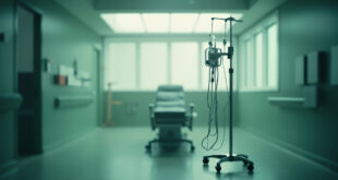 Empty medical chair beside IV stand and monitoring equipment in hospital treatment room