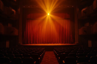 Empty Las Vegas theater stage with postponed show announcement, dimmed lights and vacant seats in amber and burgundy hues