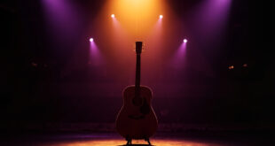 Acoustic guitar on stand under amber spotlight on empty concert stage with purple shadows