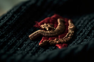Close-up of red hammer and sickle symbol with star embroidered on black knitted fabric