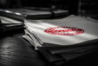 Stack of official policy documents on wooden desk with red rejection stamp, papers scattered around