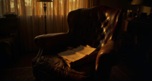 Vintage leather armchair bathed in golden light with old script pages nearby in quiet room