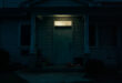 Closed front door of suburban house with children's toys scattered on front porch steps.