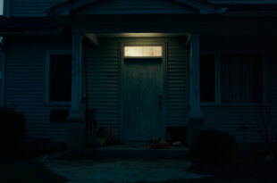 Closed front door of suburban house with children's toys scattered on front porch steps.