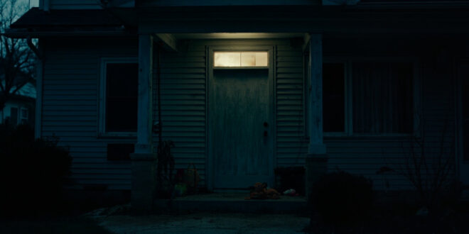 Closed front door of suburban house with children's toys scattered on front porch steps.