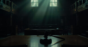 Empty parole hearing room with wooden table, vacant chairs, and official seal on wall