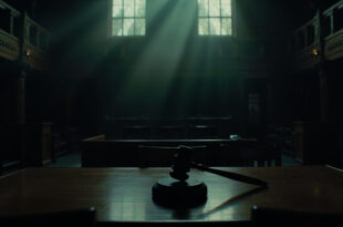 Empty parole hearing room with wooden table, vacant chairs, and official seal on wall