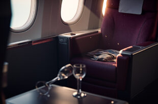 Abandoned first class cabin with empty luxury seat, overturned champagne glass on tray table amid aircraft disruption
