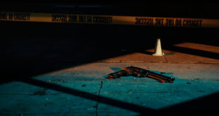 Empty urban street with police evidence markers and yellow tape cordoning off investigation area