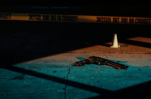 Empty urban street with police evidence markers and yellow tape cordoning off investigation area