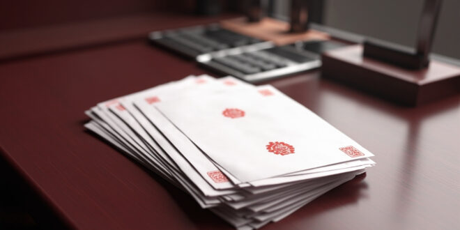 Stack of official documents with red seals next to calculator on wooden government desk