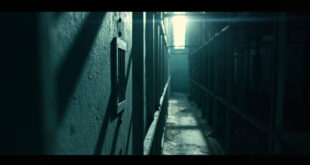 Empty prison cell with barred window and steel ventilation grate in abandoned maximum security corridor