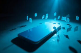 Blank smartphone displaying privacy symbols on desk in minimalist workspace bathed in blue light