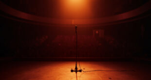 Empty microphone on stage with dramatic spotlight and vacant theater seats in background