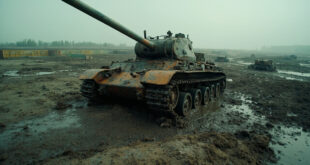 Abandoned military tank partially sunk in muddy battlefield with scattered equipment and defensive barriers.