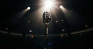 Vintage microphone standing alone under a single spotlight on an empty stage in a dimly lit, vacant concert hall.
