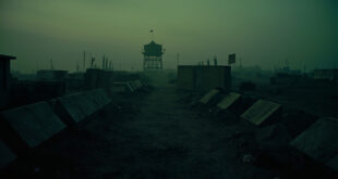 Concrete anti-tank barriers and watchtower at abandoned military checkpoint in industrial border region