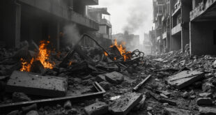 Scattered concrete debris and twisted metal from destroyed residential building with emergency vehicles nearby