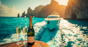 Luxury yacht on turquoise waters near Cabo coastline with champagne setup on deck