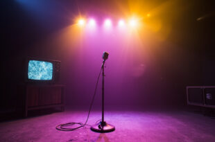 Abandoned television studio with dimmed lights, featuring a vintage microphone on empty stage and silent TV displaying static