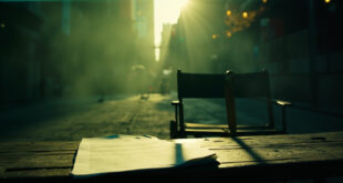 Abandoned film equipment and director's chair with script on empty movie set in New York City park during filming break